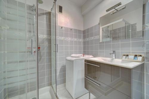 a bathroom with a glass shower and a sink at 2 room center very comfortable wi fi in Cannes
