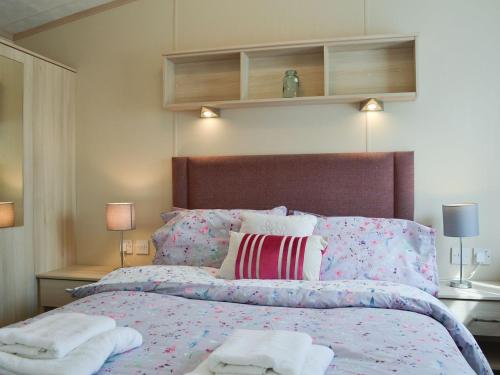 een slaapkamer met een bed met twee handdoeken erop bij Neuadd Wen Cottages - Porthdy Crey R Wen in Llanfachraeth