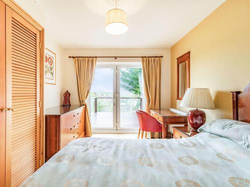 1 dormitorio con cama, escritorio y ventana en Paradise, en Cinderford