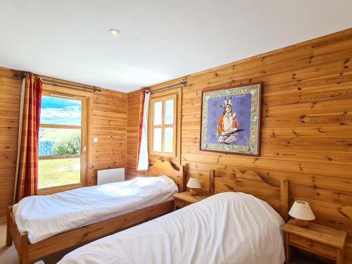 two beds in a room with wooden walls and a window at Chalet spacieux à Flaine avec sauna, cheminée et balcon - 6 chambres, proche des pistes - FR-1-425-4 in Flaine
