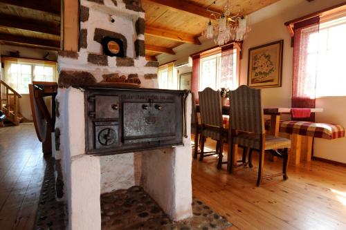 Landhouse في Olofström: موقد قديم في غرفة الطعام مع طاولة