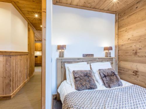 - une chambre avec un lit et un mur en bois dans l'établissement Appartement 3 Chambres avec Parking, Wifi et Proche des Remontées Mécaniques à La Clusaz - FR-1-437-46, à La Clusaz