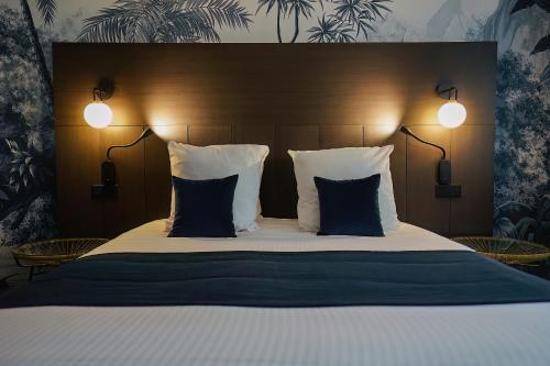 a bedroom with a large bed with two pillows at Quintessia in Orvault