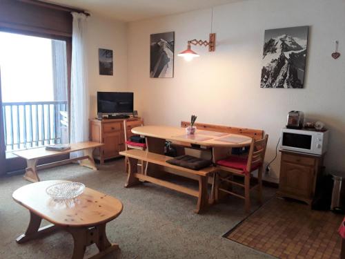a living room with a table and chairs and a television at Studio Albiez-Montrond, 1 pièce, 5 personnes - FR-1-618-9 in Albiez-Montrond