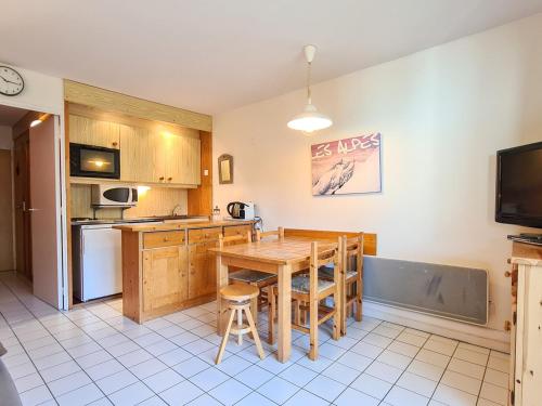 une cuisine avec une table en bois et une salle à manger dans l'établissement Studio rénové avec balcon sud, casier à ski, proche pistes et commerces - FR-1-425-156, à Flaine