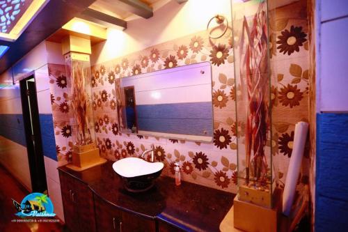 a bathroom with a sink and a mirror on a wall at Vaishnav Tours in Alleppey