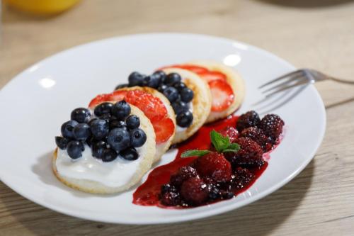 a plate of food with fruit on a table at Sporthotel Olympia in Stachy
