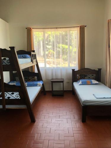 Cette chambre comprend 2 lits superposés et une fenêtre. dans l'établissement Casa de campo con hermosa vista, à Anapoima