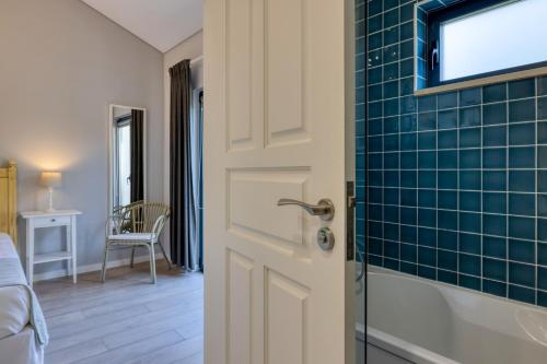 a bathroom with a door and a room with a bed at Casa Da Lagoa e Forja - Turismo Rural in Mira