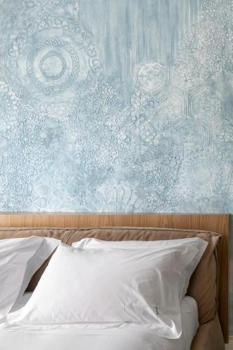 a bedroom with a blue and white wall and a bed at Ognissanti Restaurant Spa Hotel Rooftop in Trani