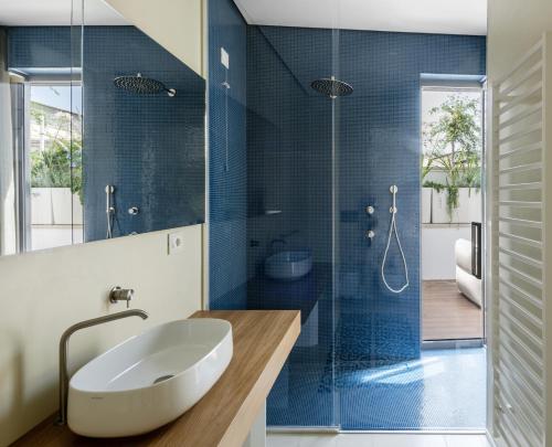 y baño con lavabo y ducha acristalada. en Ognissanti Restaurant Spa Hotel Rooftop en Trani