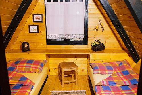 a room with two beds and a window in a cabin at Zeleni Čardaci etno apartmani in Kaludjerske Bare