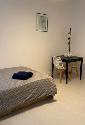 une chambre avec un lit, une table et une chaise dans l'établissement Studio moderne tout confort, à Champigny-sur-Marne