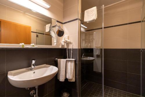 a bathroom with a sink and a shower at Hotel Garni " Am Domplatz" in Erfurt