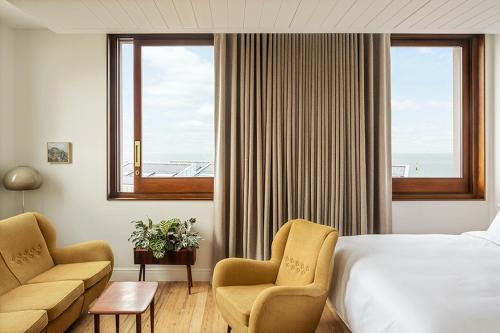 a hotel room with a bed and two chairs and a window at Fort Road Hotel in Margate