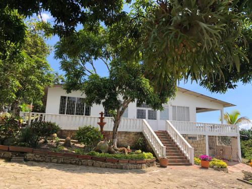 a house with stairs and a tree in front of it at Casa de campo con hermosa vista in Anapoima