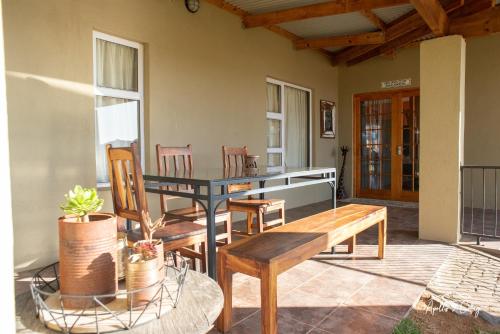 a patio with benches and a table and chairs at Apollis Cottage in Springbok
