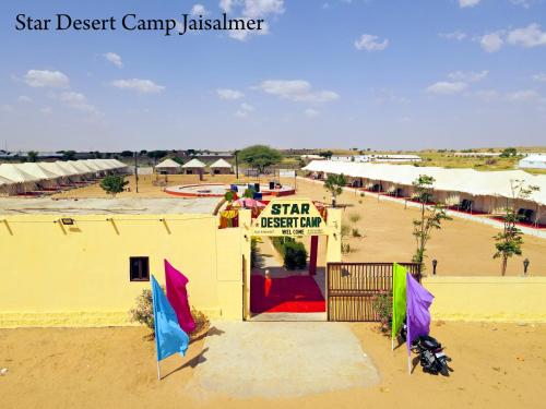 a small yellow building with a star festival sign on it at Star Desert Camp Jaisalmer in Jaisalmer