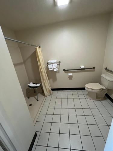 a bathroom with a toilet and a shower at Rest Inn Motel in Forrest City