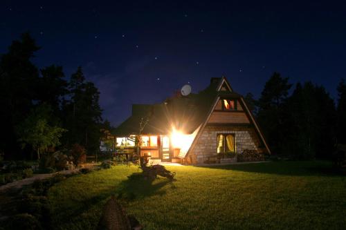 a home lit up at night with the light on at Zeleni Čardaci etno apartmani in Kaludjerske Bare