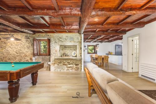 ein Wohnzimmer mit einem Billardtisch und eine Küche in der Unterkunft Casa do Monte Locally Yours in Caminha
