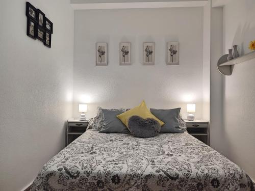 a bedroom with a bed with two night stands and two lamps at Apartamento La Muralla de San Lorenzo in Córdoba