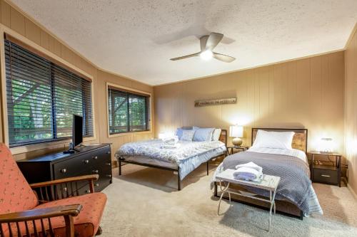 1 dormitorio con 2 camas, TV y silla en Treehouse Lodge at Sugar Mountain, en Sugar Mountain