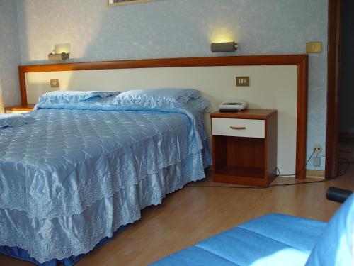 Schlafzimmer mit einem Bett und einem Telefon auf einem Tisch in der Unterkunft Vecchia Fattoria in Ceriana