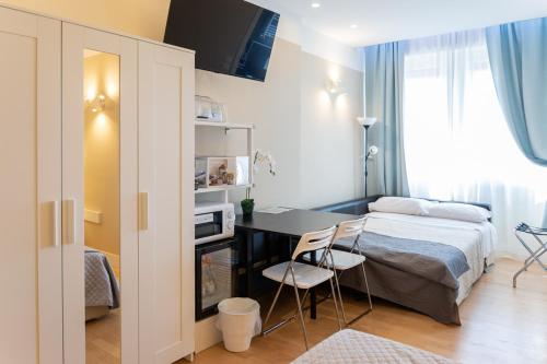 een slaapkamer met een bed en een bureau met 2 stoelen bij Pescara Centro luxury suite II Deluxe Rooms in Pescara