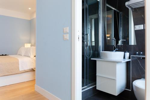 a bathroom with a sink and a toilet and a bed at Pescara Centro luxury suite II Deluxe Rooms in Pescara