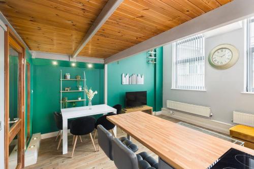 a dining room with green walls and a wooden ceiling at The Exquisite Duplex of Central Nottingham in Nottingham