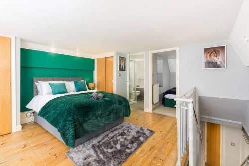 a bedroom with a green accent wall and a bed at The Exquisite Duplex of Central Nottingham in Nottingham