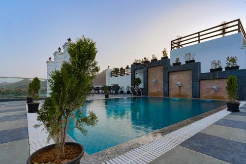 a large swimming pool with a tree in a pot at Revaas Lake View Boutique Hotel in Udaipur