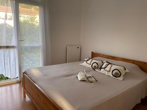 - une chambre avec un lit avec deux oreillers et une fenêtre dans l'établissement Appartement les pieds dans l'eau, à Saint-Mandrier-sur-Mer