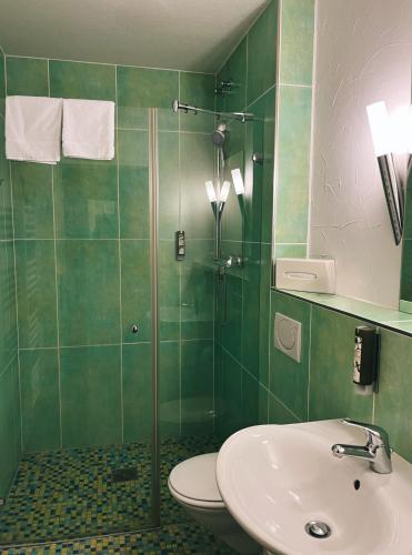 a bathroom with a shower and a toilet and a sink at Boutique Hotel VIVA CREATIVO in Hannover