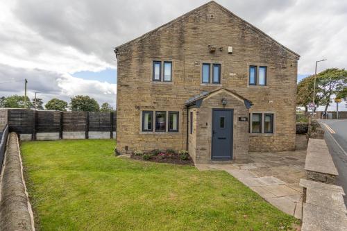a brick house with a blue door in a yard at Hill Top in Bradford