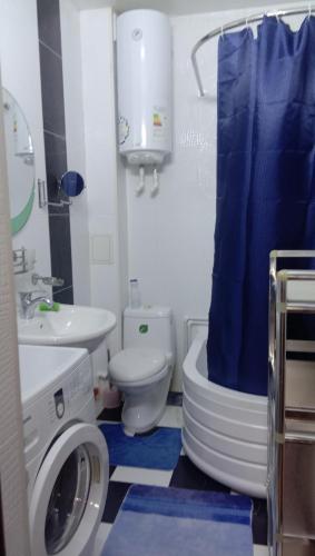 a bathroom with a toilet sink and a washing machine at Мтко-1 in Khujand