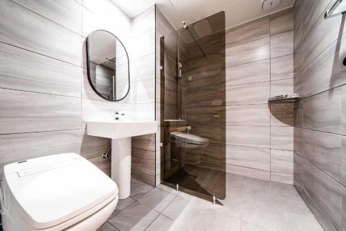 ein Badezimmer mit einem WC, einem Waschbecken und einem Spiegel in der Unterkunft The Amber Hotel in Yangpyeong