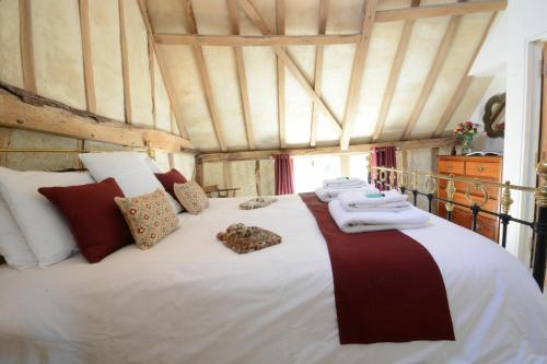 a bedroom with a large bed with towels on it at Yew Tree Farm Barn, Worlingworth in Worlingworth