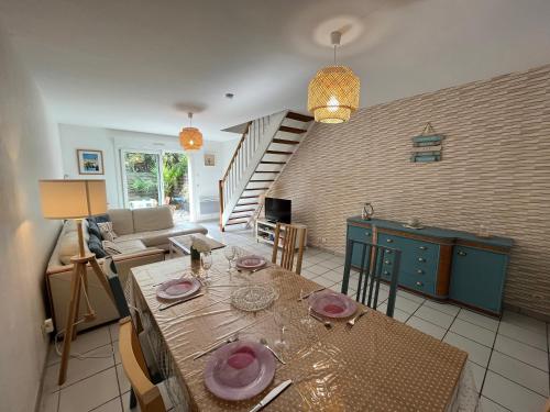 Il comprend une cuisine et un salon avec une table et un escalier. dans l'établissement Maison calme avec terrasse - Calypso, à Ouistreham