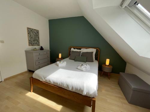 um quarto com uma cama e uma parede verde em Calypso YourHostHelper em Ouistreham