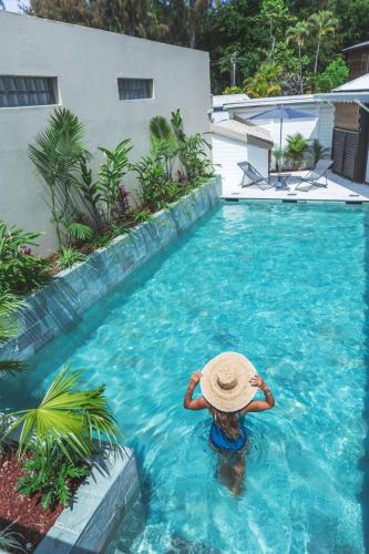 a person in a straw hat in a swimming pool at Ilet du Lagon in La Saline les Bains
