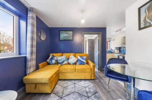 a living room with a yellow couch and blue walls at The Exquisite Harrow Gem -Parking in Harrow Weald