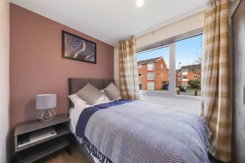 a bedroom with a bed and a large window at The Exquisite Harrow Gem -Parking in Harrow Weald