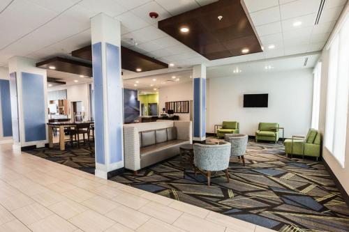 a lobby with a waiting area with chairs and tables at Holiday Inn Express & Suites Edmonton N - St Albert, an IHG Hotel in St. Albert