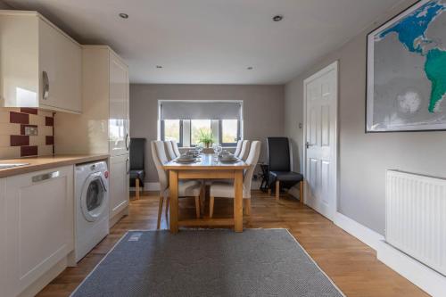 a kitchen and dining room with a table and a washing machine at Hill Top in Bradford