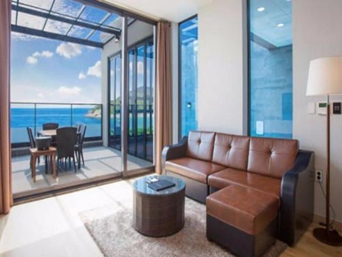 a living room with a couch and a table with a view at Demare Pension in Yeosu