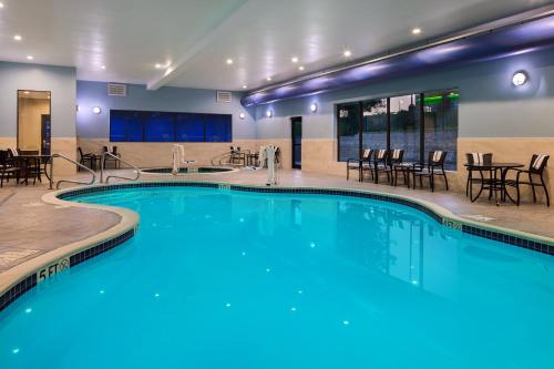 einen Pool mit Tischen und Stühlen in einem Hotel in der Unterkunft Holiday Inn Express & Suites Bridgeport, an IHG Hotel in Bridgeport