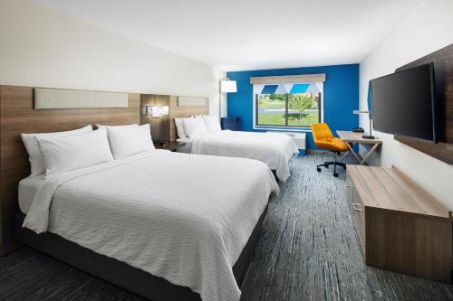 a hotel room with two beds and a flat screen tv at Holiday Inn Express & Suites Bridgeport by IHG in Bridgeport