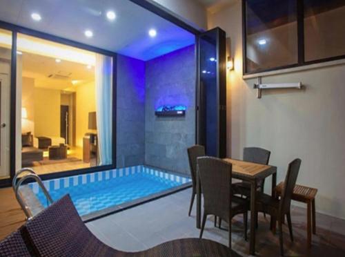 a dining room with a table and a swimming pool at Demare Pension in Yeosu
